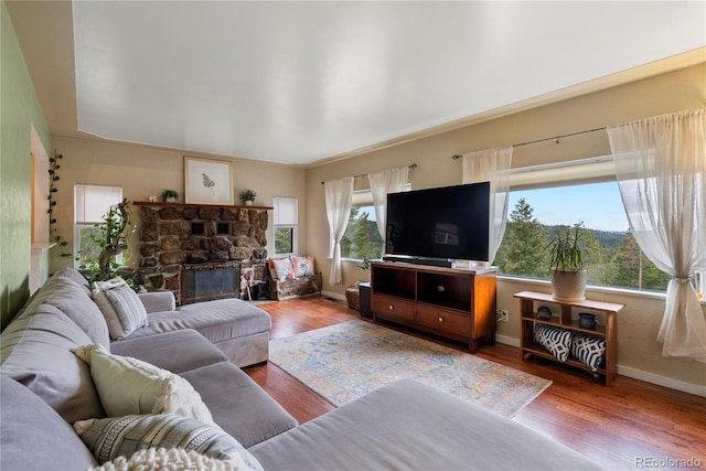 8701 Majestic View Dr, Conifer, CO 80433 - living room featuring baseboards, wood finished floors, and a stone fireplace