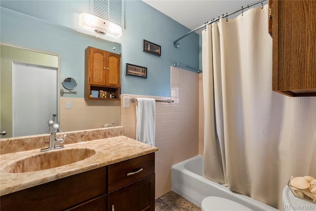 8701 Majestic View Dr, Conifer, CO 80433 - bathroom featuring toilet, vanity, tile walls, shower / tub combo, and a wainscoted wall