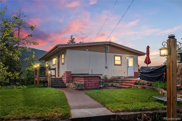 8701 Majestic View Dr, Conifer, CO 80433 - back of property at dusk with a yard and stucco siding