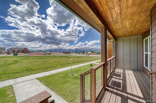 wooden terrace featuring a lawn and a mountain view