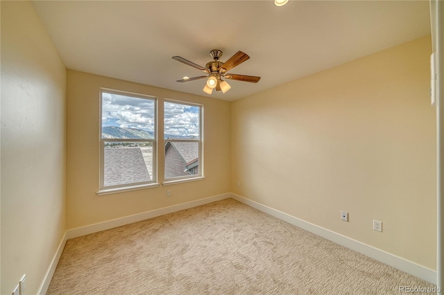 carpeted spare room featuring ceiling fan