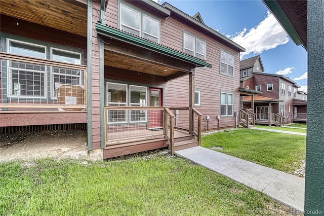 rear view of property with a deck and a yard