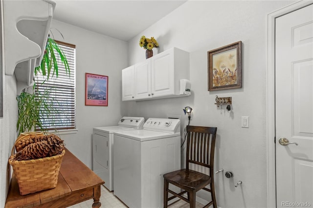 laundry room featuring cabinets, a healthy amount of sunlight, and washing machine and clothes dryer