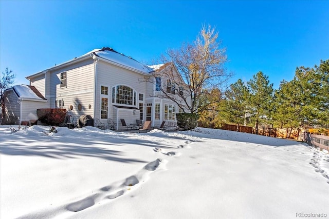 view of snow covered rear of property