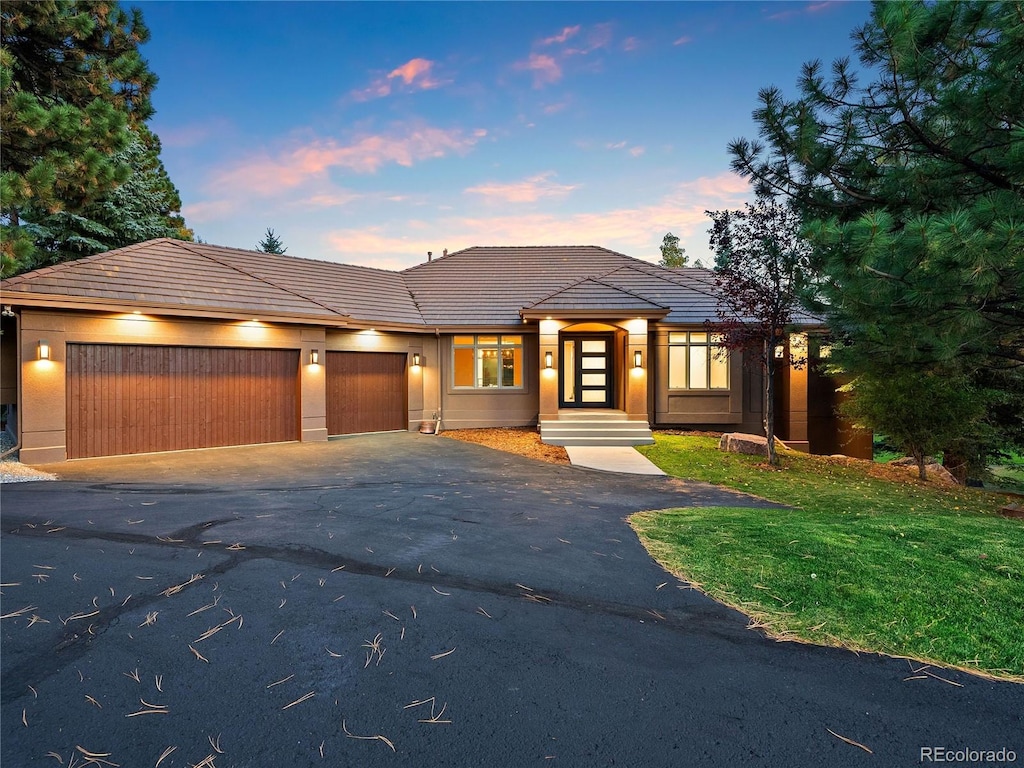 prairie-style home with a yard and a garage