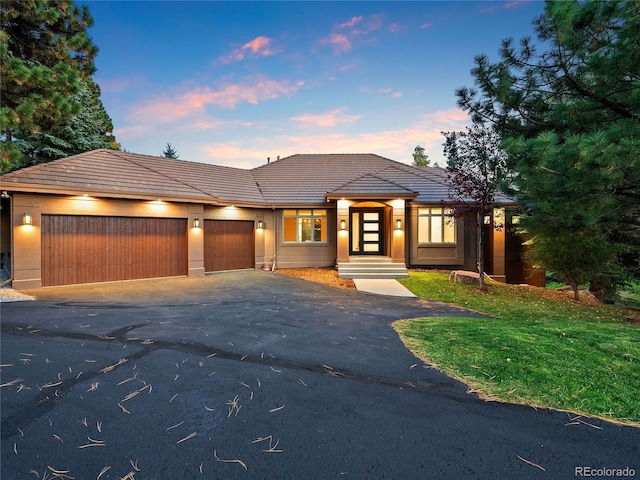 prairie-style home with a yard and a garage