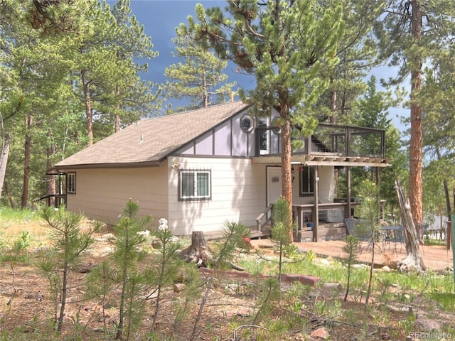 187 Johnson Rd, Bailey, CO 80421 - rear view of house with a shingled roof, a deck, and a patio area