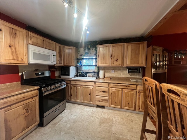 187 Johnson Rd, Bailey, CO 80421 - kitchen featuring white microwave, gas stove, backsplash, and light countertops