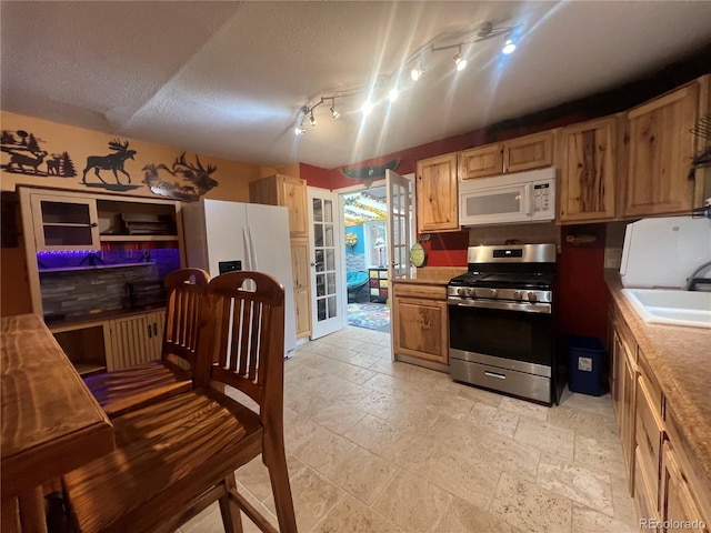 187 Johnson Rd, Bailey, CO 80421 - kitchen with white appliances, stone tile flooring, and a textured ceiling