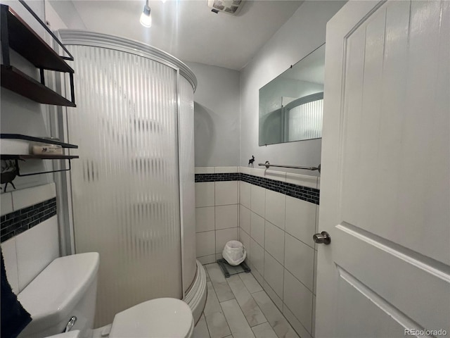187 Johnson Rd, Bailey, CO 80421 - bathroom with tile walls, a shower stall, and marble look tiles