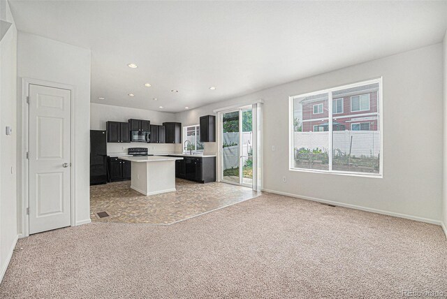 5550 Malta St, Denver, CO 80249 - kitchen with black appliances, light colored carpet, light countertops, a center island, and open floor plan