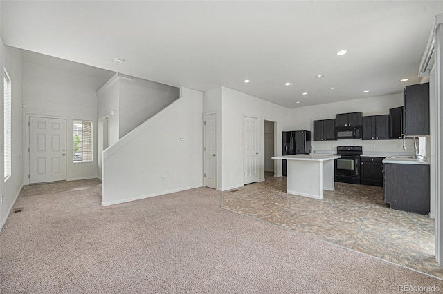 5550 Malta St, Denver, CO 80249 - kitchen with black appliances, open floor plan, light colored carpet, dark cabinets, and light countertops