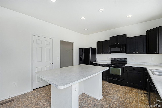 5550 Malta St, Denver, CO 80249 - kitchen with black appliances, dark cabinets, light countertops, a kitchen island, and recessed lighting