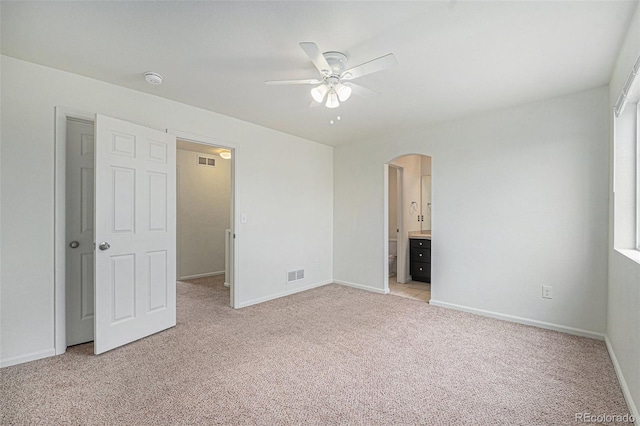 5550 Malta St, Denver, CO 80249 - unfurnished bedroom with arched walkways, light carpet, ensuite bathroom, and ceiling fan