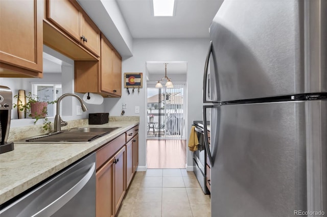 8751 Chase Dr Unit 181, Arvada, CO 80003 - kitchen featuring appliances with stainless steel finishes, light countertops, light tile patterned flooring, and plenty of natural light