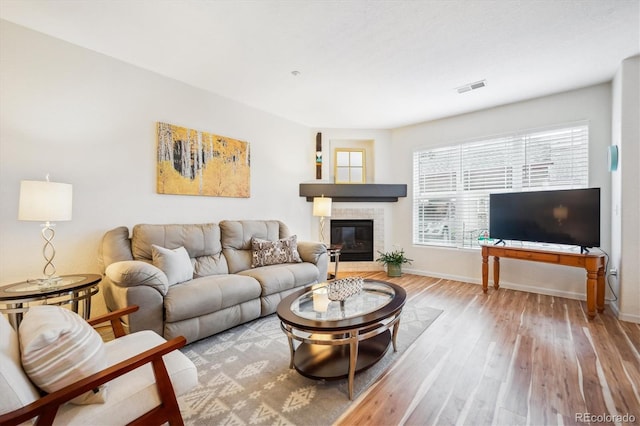 8520 S Holland Ln Unit 102, Littleton, CO 80128 - living room with wood finished floors, a tiled fireplace, and baseboards