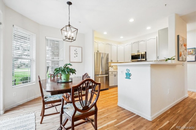 8520 S Holland Ln Unit 102, Littleton, CO 80128 - dining space featuring light wood-style floors, baseboards, a chandelier, and recessed lighting