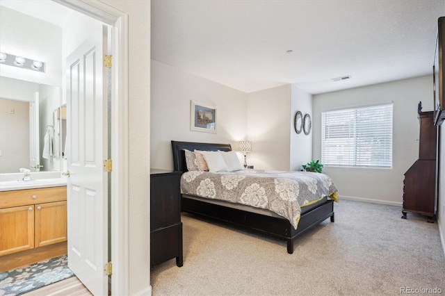 8520 S Holland Ln Unit 102, Littleton, CO 80128 - bedroom with a sink, light carpet, connected bathroom, and baseboards