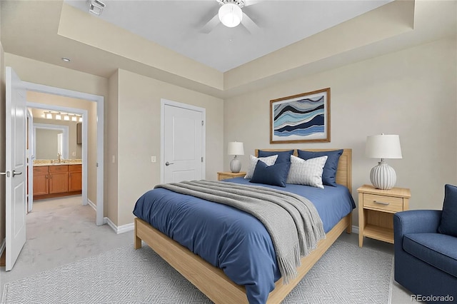 bedroom featuring ceiling fan, a raised ceiling, and light carpet