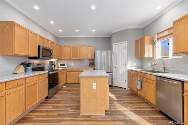 kitchen featuring a kitchen island, appliances with stainless steel finishes, sink, ornamental molding, and light hardwood / wood-style flooring