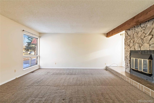 unfurnished living room with a textured ceiling, beam ceiling, carpet floors, and a fireplace