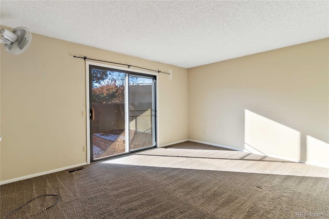 carpeted empty room with a textured ceiling