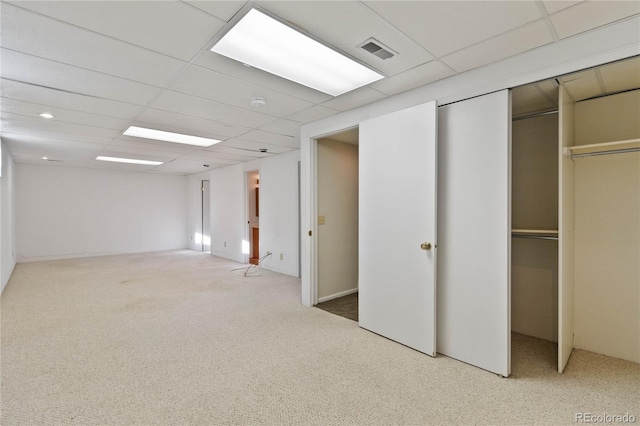 interior space with a drop ceiling and carpet floors