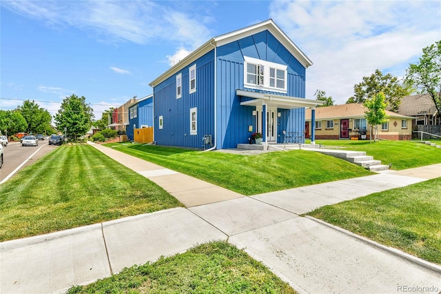 3178 N Race St, Denver, CO 80205 - view of front of property with board and batten siding, covered porch, and a front yard