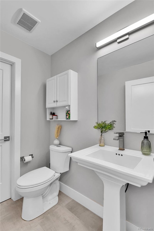 3178 N Race St, Denver, CO 80205 - bathroom featuring toilet, wood finished floors, baseboards, and a sink