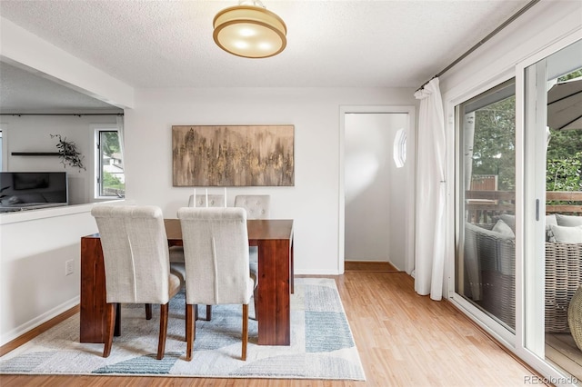 8369 W 77th Way, Arvada, CO 80005 - dining room with wood finished floors, healthy amount of natural light, and a textured ceiling