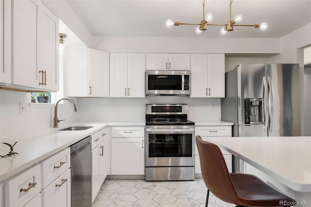 8369 W 77th Way, Arvada, CO 80005 - kitchen with stainless steel appliances, light countertops, white cabinetry, and a chandelier