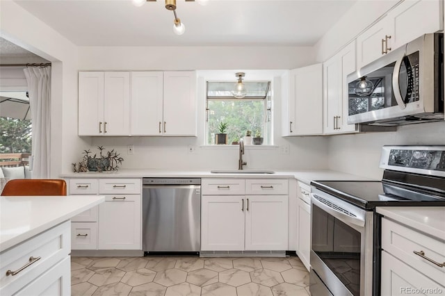 8369 W 77th Way, Arvada, CO 80005 - kitchen with appliances with stainless steel finishes, white cabinetry, and light countertops
