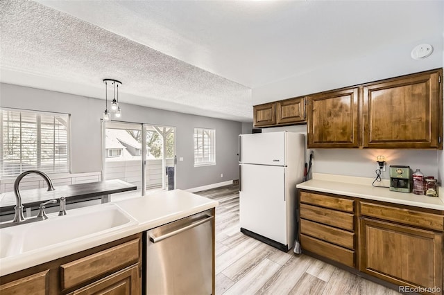 10685 W Apishapa Pass, Littleton, CO 80127 - kitchen with freestanding refrigerator, stainless steel dishwasher, a sink, light wood finished floors, and light countertops
