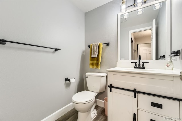 10685 W Apishapa Pass, Littleton, CO 80127 - bathroom with wood finished floors, vanity, toilet, and baseboards