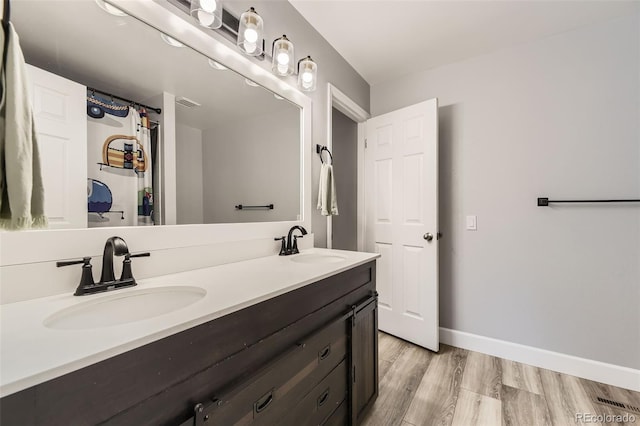 10685 W Apishapa Pass, Littleton, CO 80127 - full bathroom featuring double vanity, wood finished floors, and baseboards