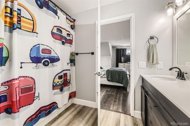 10685 W Apishapa Pass, Littleton, CO 80127 - bathroom with wood finished floors, vanity, baseboards, and ensuite bath