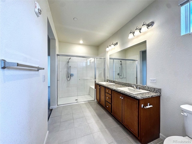 3865 Presidio Pt Unit 101, Colorado Springs, CO 80920 - bathroom featuring tile patterned floors, a shower stall, toilet, double vanity, and baseboards