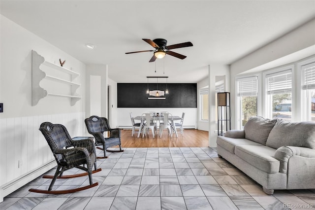 living room featuring light wood-type flooring, baseboard heating, and ceiling fan