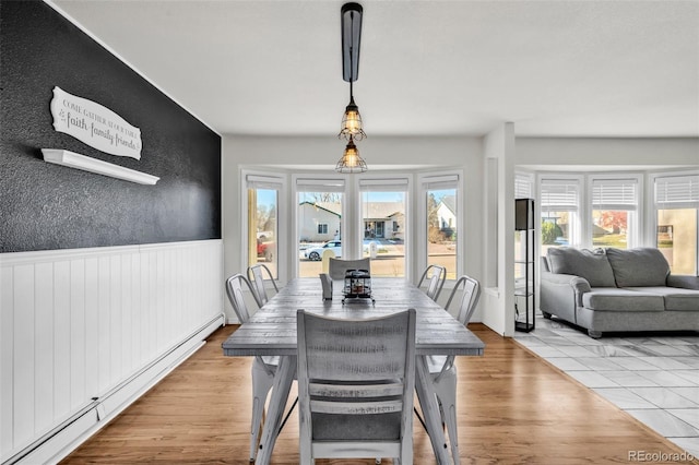 dining room with a baseboard radiator and light hardwood / wood-style flooring