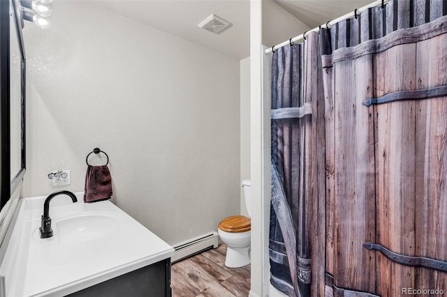 bathroom with hardwood / wood-style floors, vanity, a baseboard radiator, and toilet