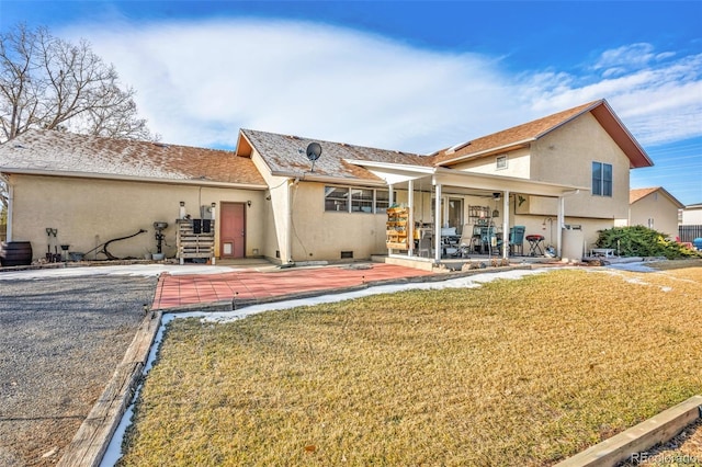 back of property featuring a lawn and a patio area