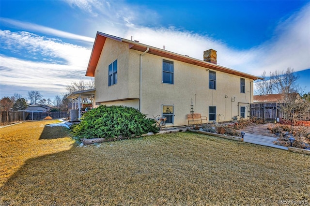 rear view of house featuring a yard