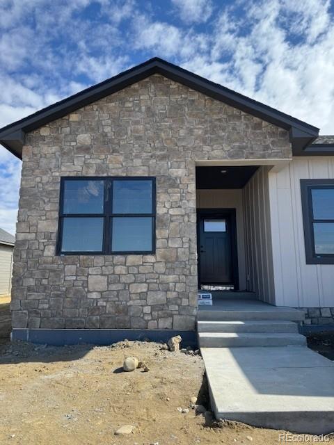 view of exterior entry featuring stone siding