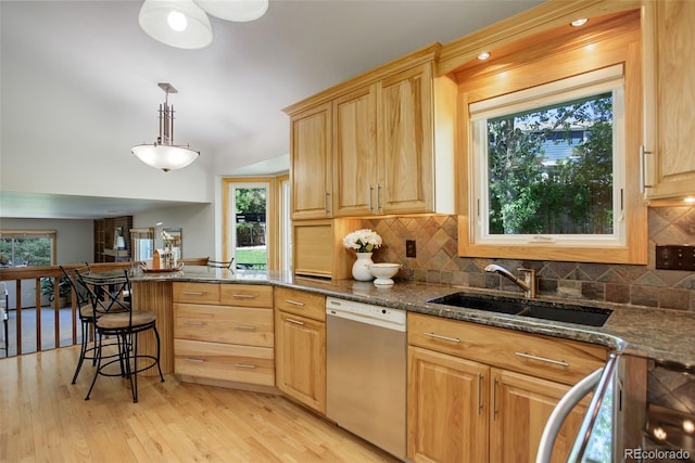 7877 W 110th Dr, Westminster, CO 80021 - kitchen featuring dishwashing machine, a sink, a peninsula, tasteful backsplash, and light wood-style floors