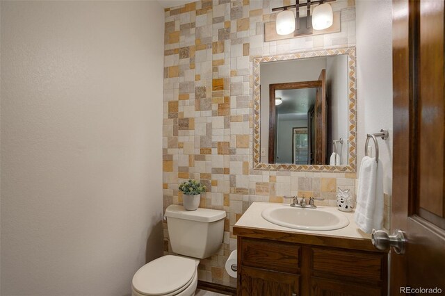 7877 W 110th Dr, Westminster, CO 80021 - half bath featuring tile walls, toilet, vanity, and decorative backsplash