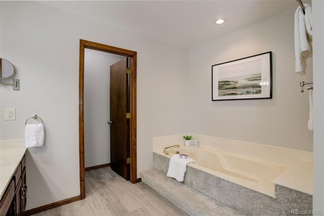 7877 W 110th Dr, Westminster, CO 80021 - bathroom featuring wood finished floors, vanity, a bath, and recessed lighting