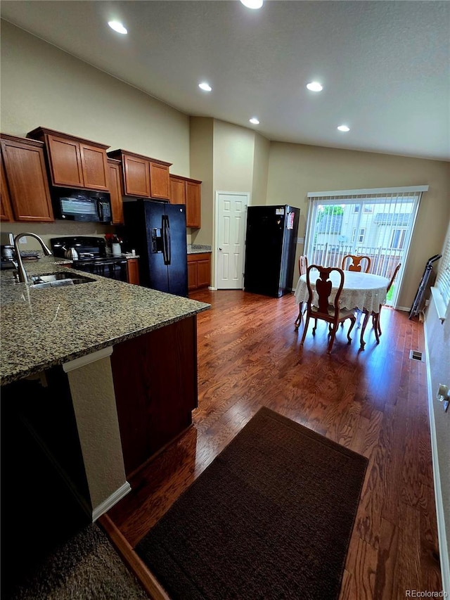5131 Delphinium Cir, Brighton, CO 80601 - kitchen with black appliances, a sink, brown cabinets, stone counters, and recessed lighting