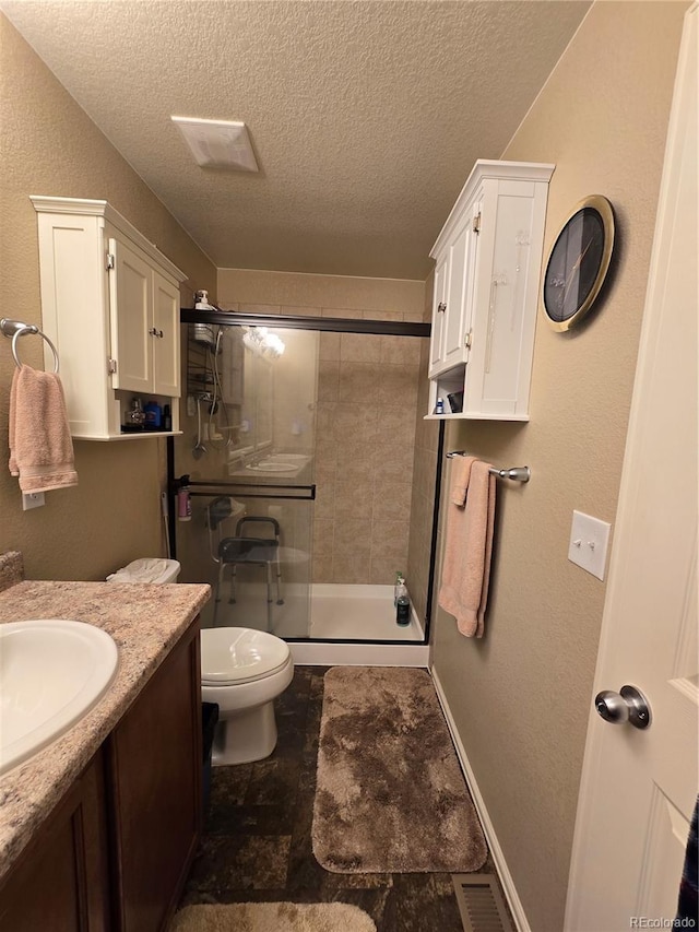 5131 Delphinium Cir, Brighton, CO 80601 - full bathroom with toilet, a textured ceiling, a stall shower, vanity, and stone finish flooring