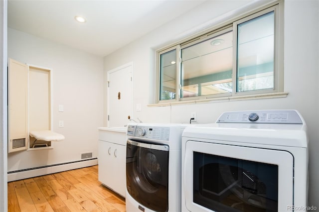 6600 E 4th Ave, Denver, CO 80220 - washroom featuring cabinet space, a baseboard heating unit, washer and dryer, light wood-type flooring, and recessed lighting