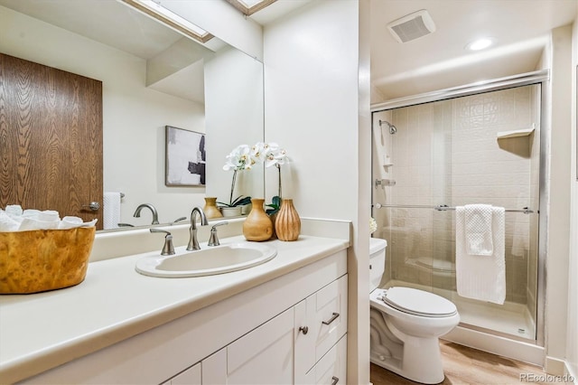 7420 E Quincy Ave Unit 304, Denver, CO 80237 - bathroom with toilet, vanity, a shower stall, and wood finished floors